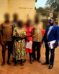 Pictured are Rachel (pseudonym) and her family posing with the JCU paralegal officer after their release from Kiryandongo Central Police Station (CPS). 